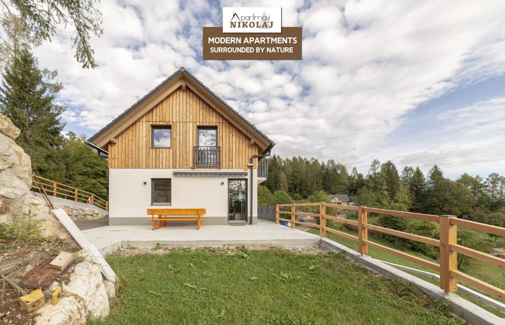 una casa en el bosque con un cartel que lee la arquitectura noruega de la montaña niagara en Apartments Nikolaj, en Preddvor