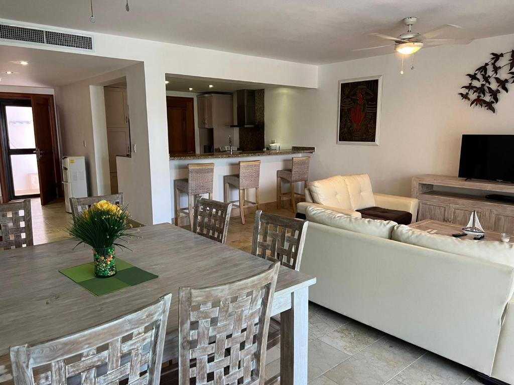 ein Wohnzimmer mit einem Tisch und einem Sofa in der Unterkunft Bello y cómodo apartamento, frente al mar in Punta Cana