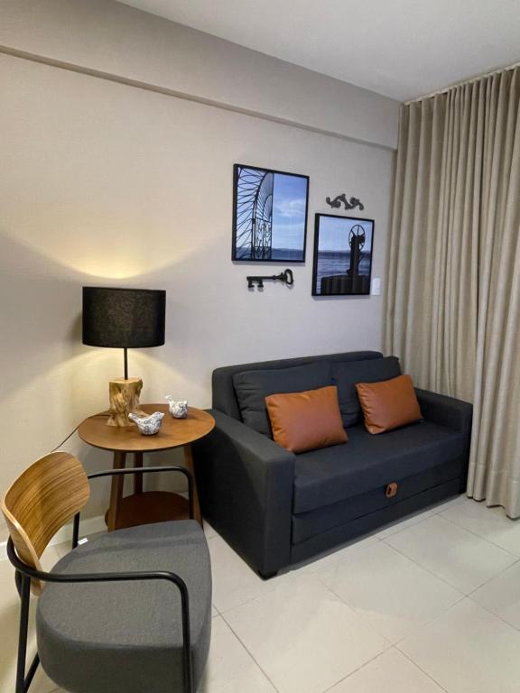 sala de estar con sofá azul y mesa en Novo quarto e sala - J. Armação - Vista Mar!, en Salvador