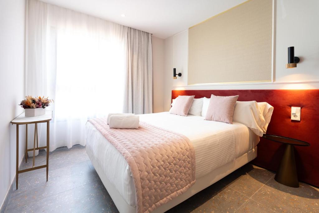 a bedroom with a large bed and a window at ASA Hotel La Marina in Ondara