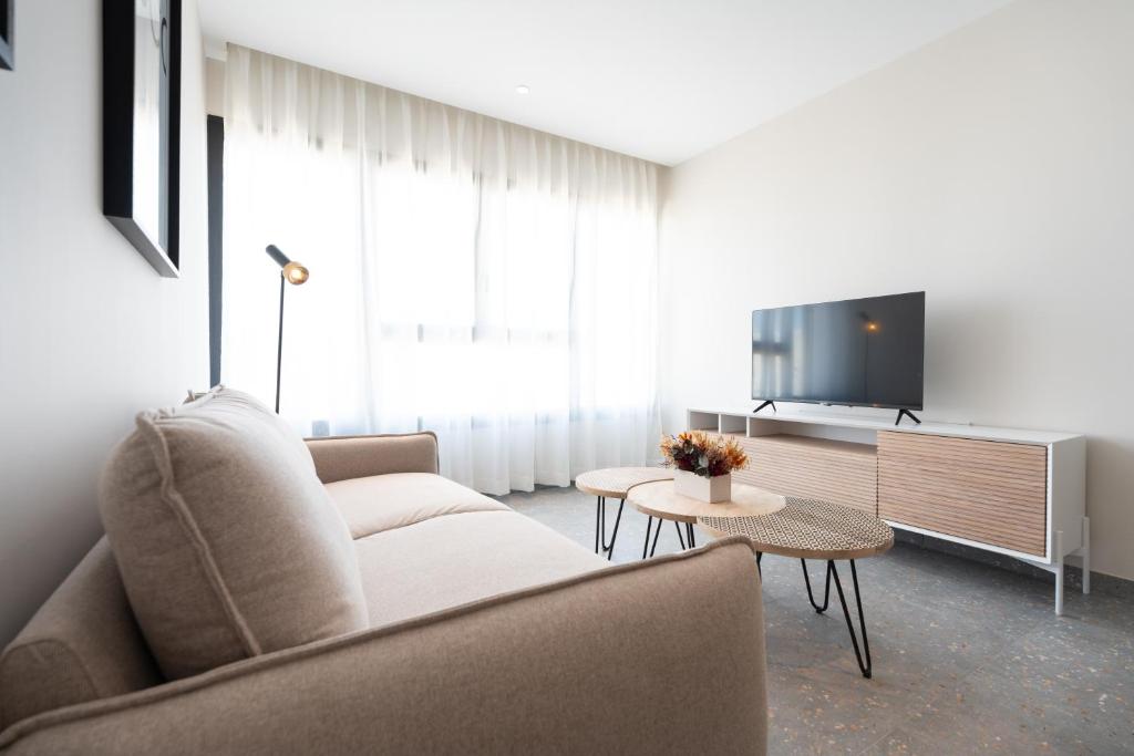 a living room with a couch and a tv at ASA Hotel La Marina in Ondara