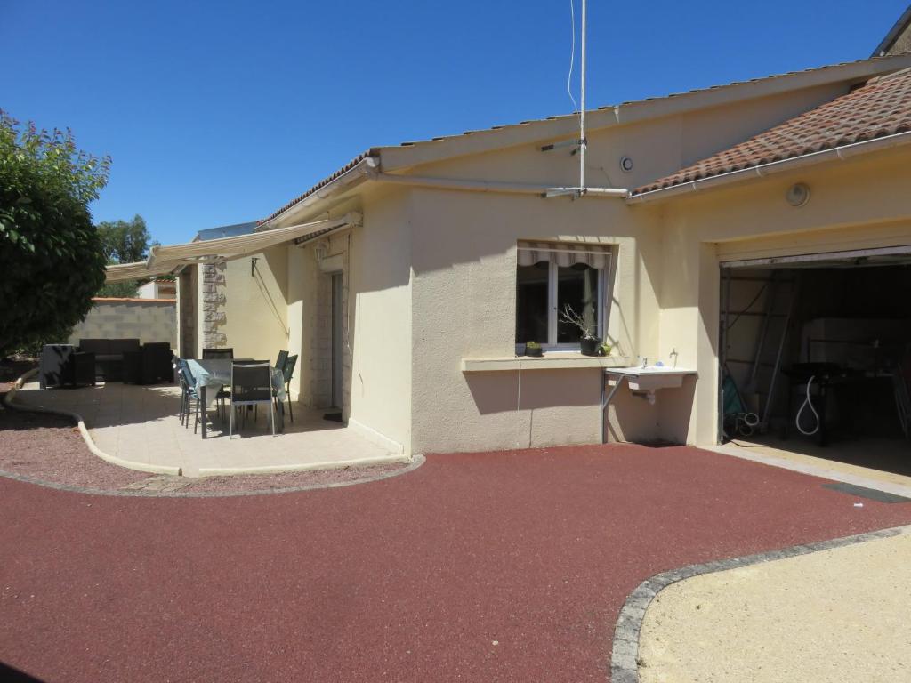een huis met een terras met een tafel en stoelen bij Clos Saint Hilaire in Longeville-sur-Mer