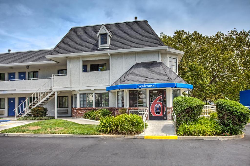 a white house with a red door in front of it at Motel 6-Fairfield, CA - North in Fairfield