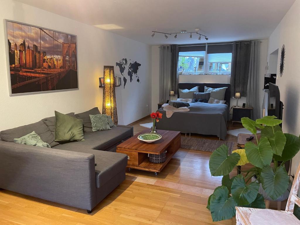 a living room with a couch and a bed at Modernes Appartement im Grünen in Cologne