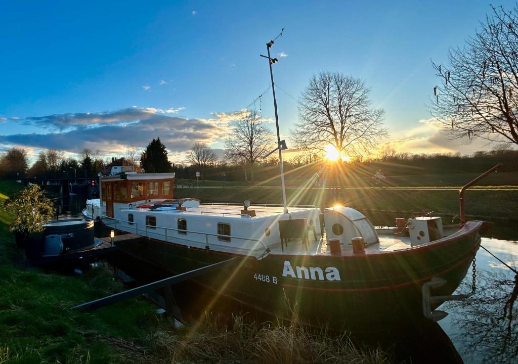 a boat sitting in the water at sunset at Au fil de l'eau et Spa in Plobsheim