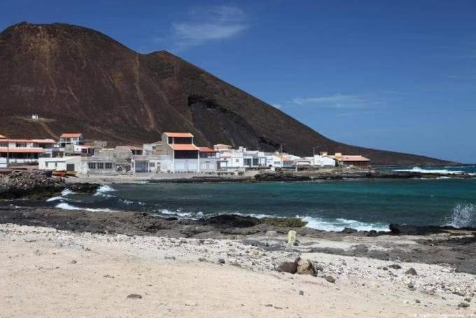 a group of houses on a beach next to the water at L2B - São Vicente in Mindelo