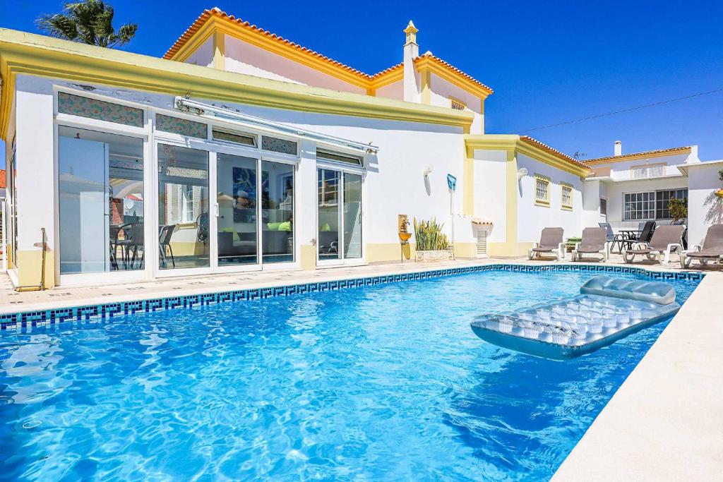 a swimming pool in front of a house at Villa Vivienda Rosa in Albufeira