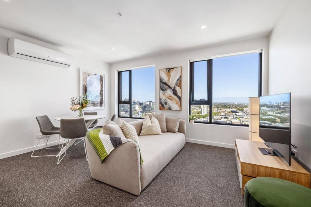 uma sala de estar com um sofá e uma mesa em Modern Urban Oasis 2 bed Apartment em Melbourne