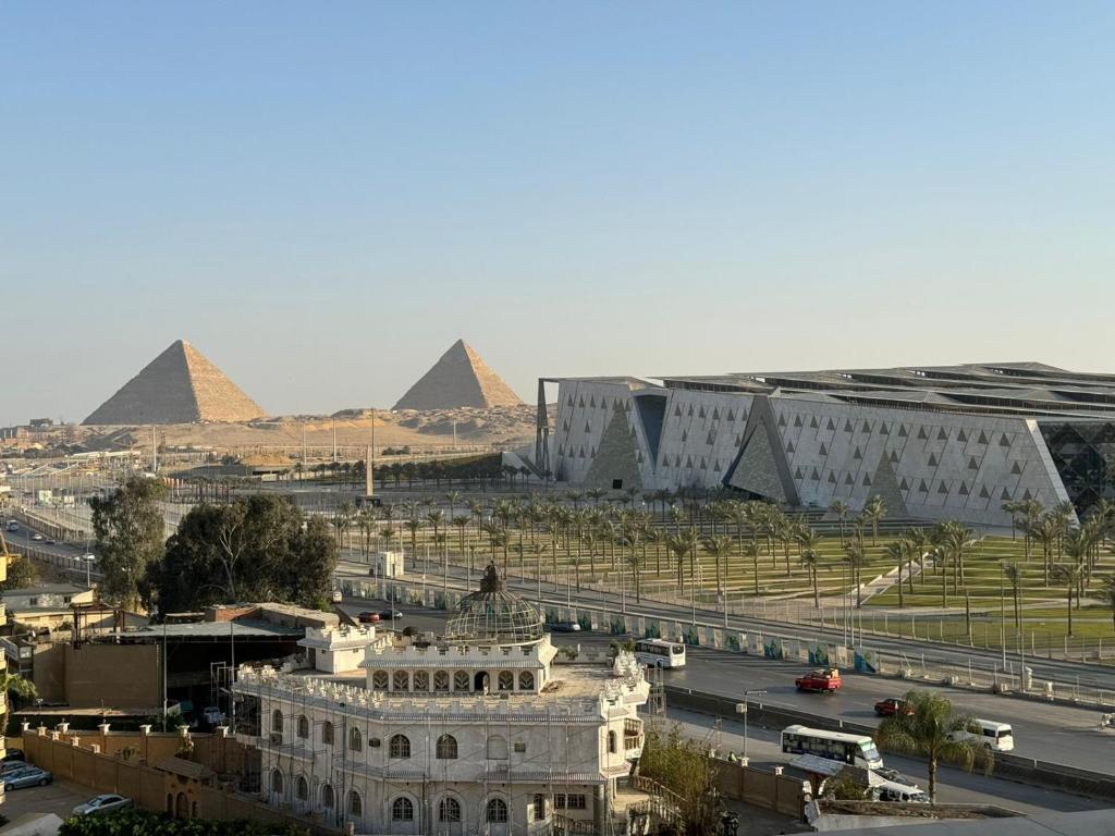 a view of a building with pyramids in the background at Museum comfort view Giza ' pyramids in Giza