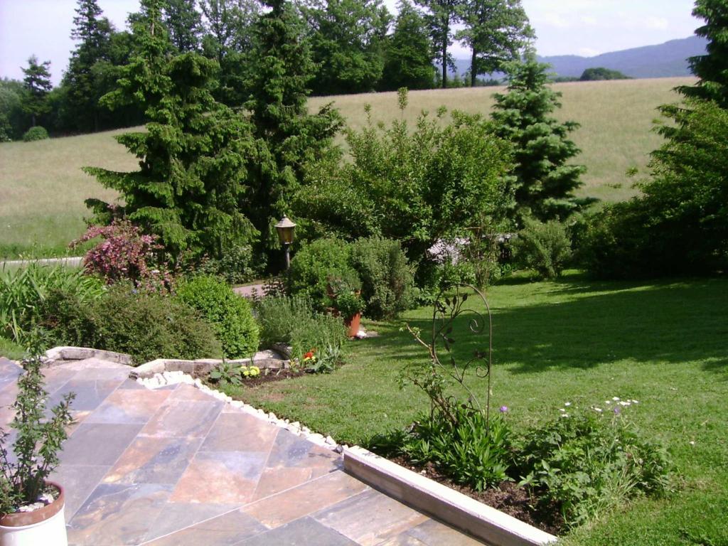 um jardim com plantas e árvores num campo em Ferienwohnung in Haidach em Pettighofen