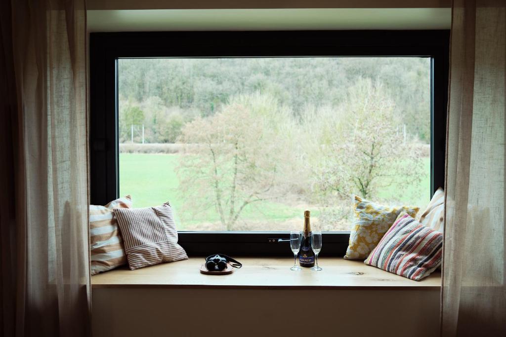 a window with a bottle of wine and a glass at Penthouse : immersion dans la nature in Durbuy