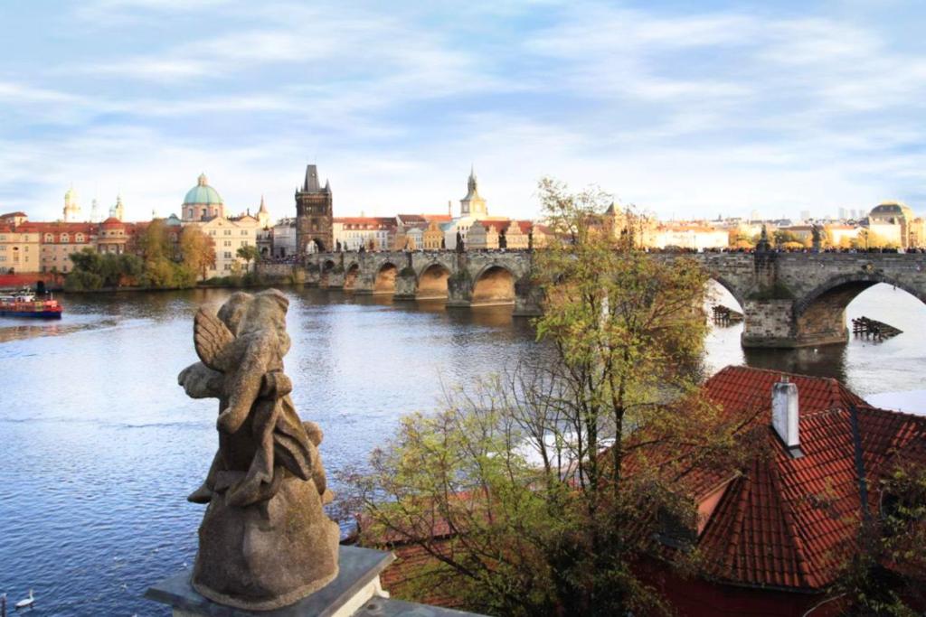 a view of a bridge over a river with a statue at Residence Charles Bridge in Prague