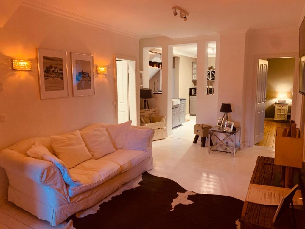 una sala de estar con un sofá blanco en una habitación en The Hampton Hock's - Wellness & Wine en Freinsheim