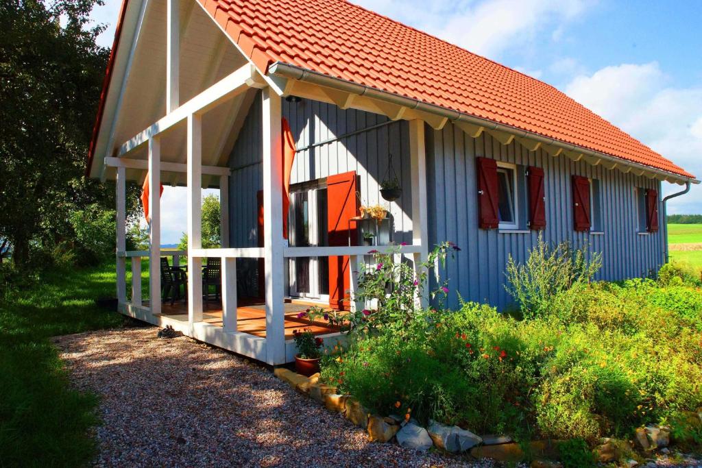 ein kleines blaues Haus mit orangefarbenem Dach in der Unterkunft Feriendorf Wutachschlucht in Mundelfingen