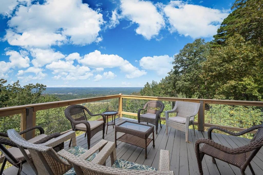 a deck with chairs and tables and a view of the ocean at Rubys Roost in Mentone