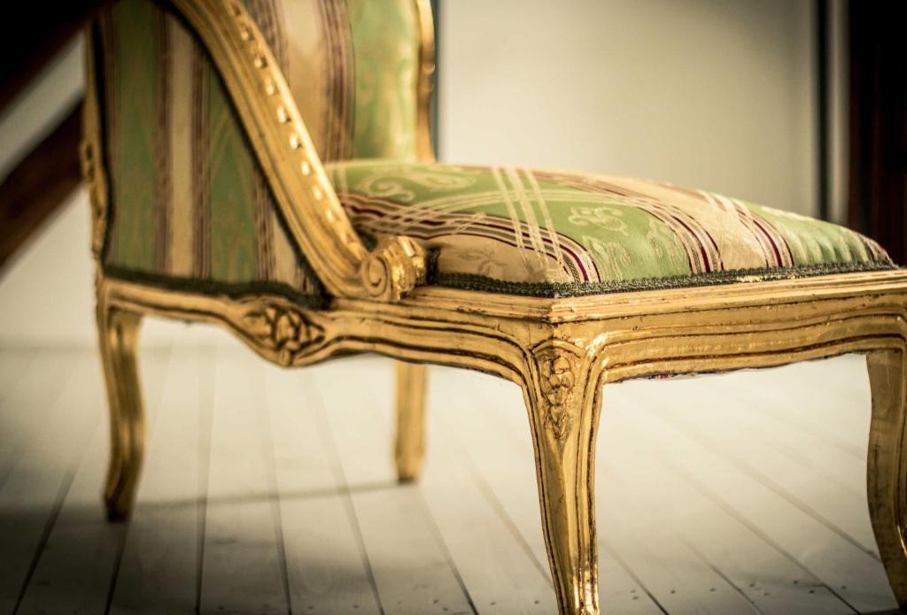 a green and gold chair sitting on a floor at Chalet Sch l afbock 