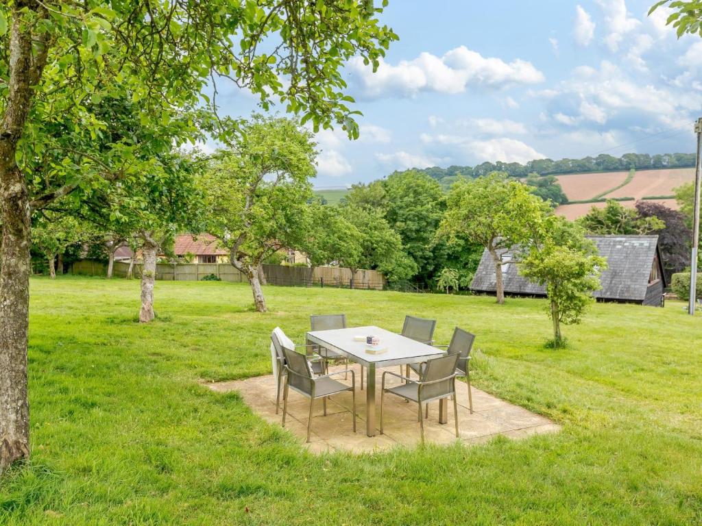 a table and chairs in a yard with a field at 3 Bed in Tiverton 53565 in Cullompton