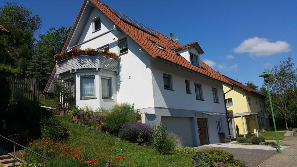 una casa bianca con un vaso di fiori di Ferienwohnung Am Südhang a Ettenheim