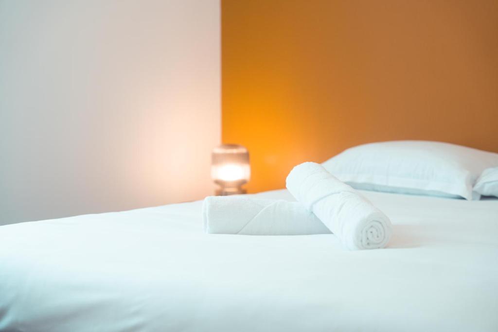 - 2 lits avec des draps blancs et des serviettes dans l'établissement Le Cabernet, T2 centre ville, à Tours