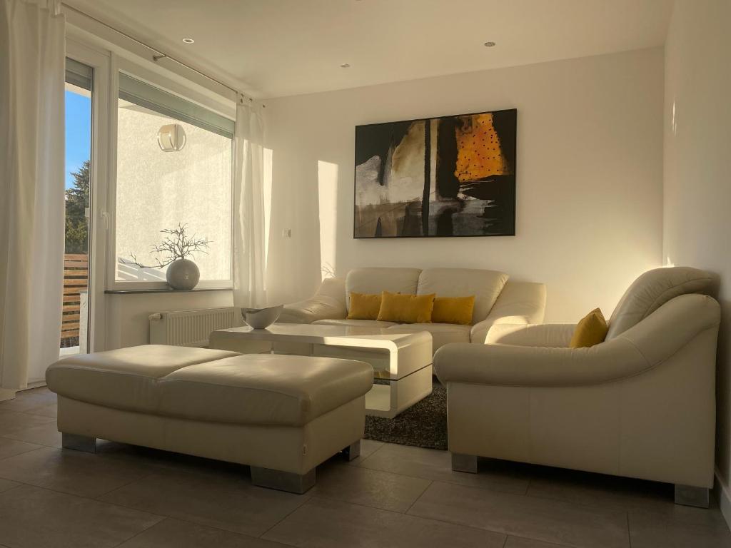 - un salon avec un canapé et deux canapés dans l'établissement Schöne Wohnung mit Balkon, à Hanovre