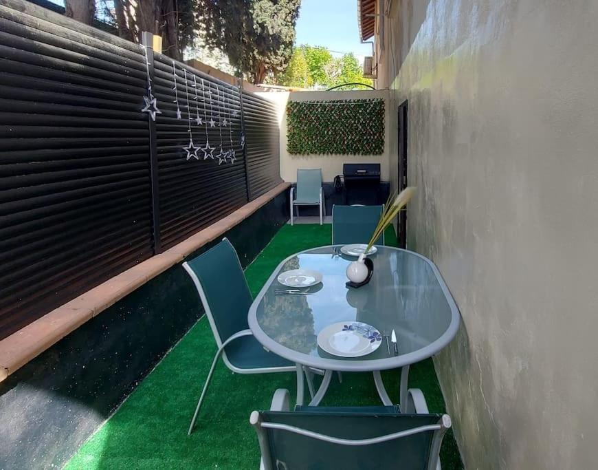 d'une table et de chaises sur un balcon avec de l'herbe verte dans l'établissement Charmant appartement proche de toutes commodités, à Marseille