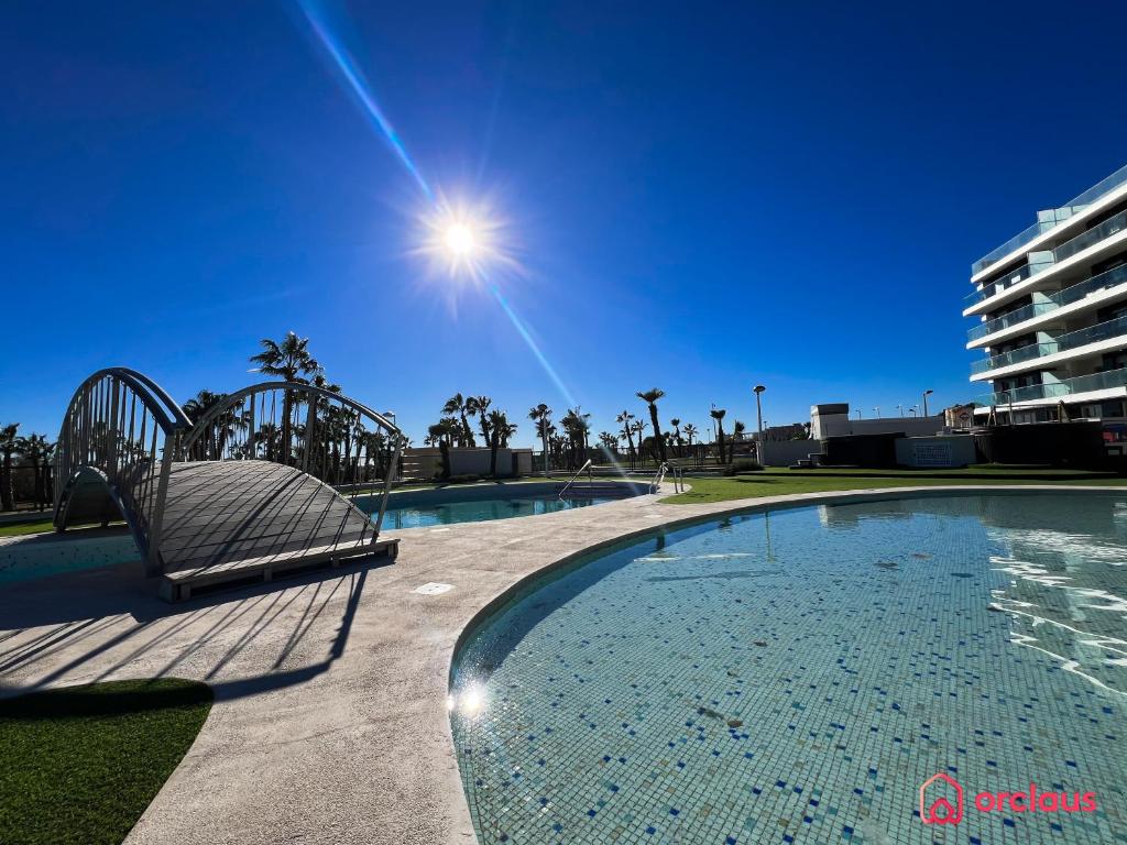 einen Pool mit einem Stuhl neben einem Gebäude in der Unterkunft El Eden Costero in Cabanes