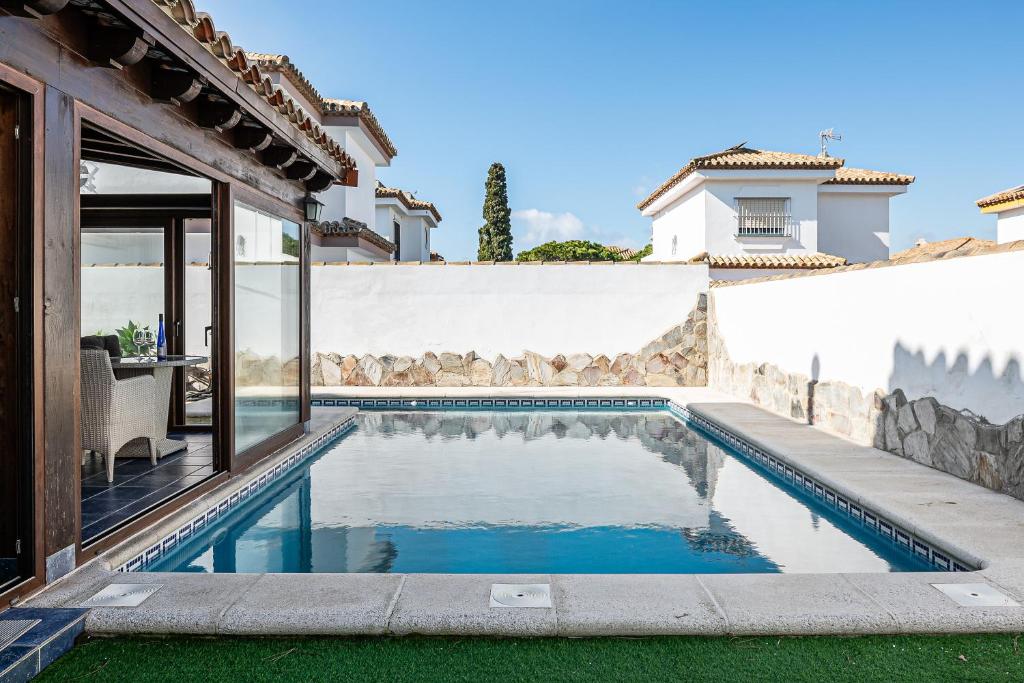 a swimming pool in the backyard of a house at Chalet Estribor in Chiclana de la Frontera
