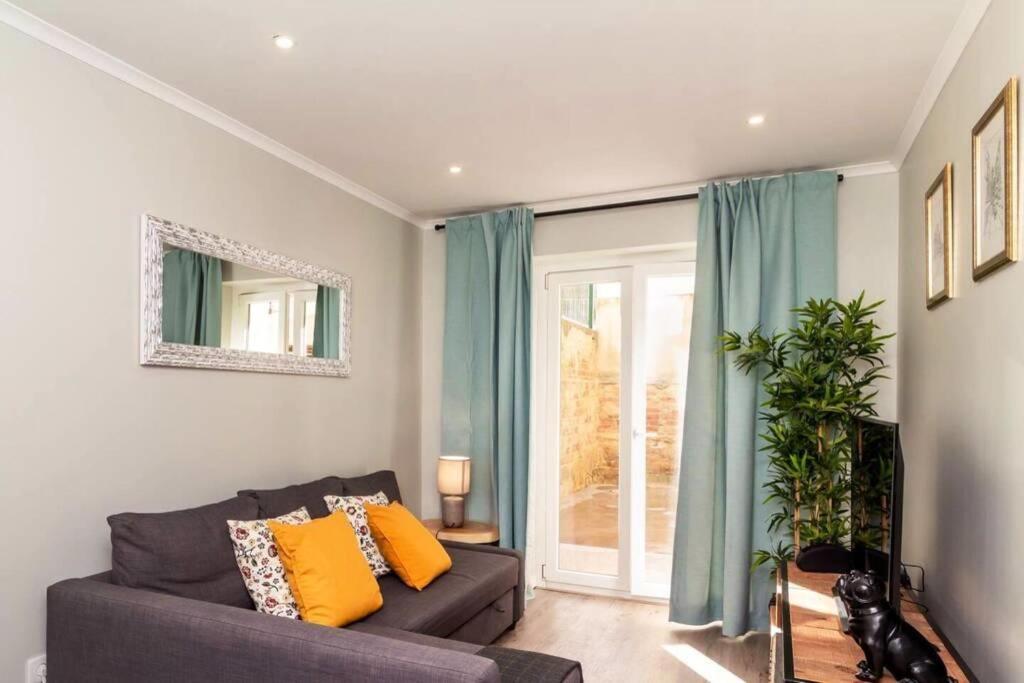 - un salon avec un canapé et une fenêtre dans l'établissement Lapa III Lisbon apartment, à Lisbonne
