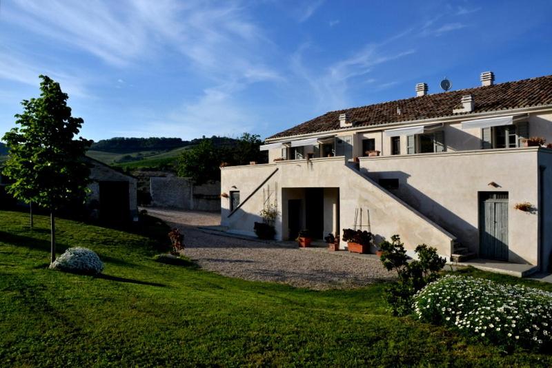 uma grande casa branca com um jardim de relva em Casa Vacanze La Vecchia Fonte em Monteprandone