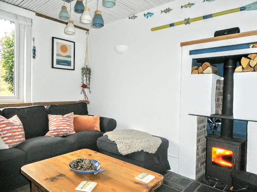 a living room with a couch and a wood stove at Victoria Cottage in St. Agnes