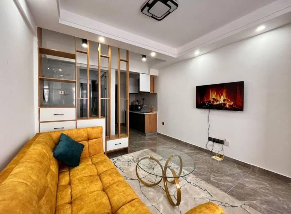 sala de estar con sofá y chimenea en Amazing stylish Studio Apartment in Kilimani Nairobi, en Nairobi