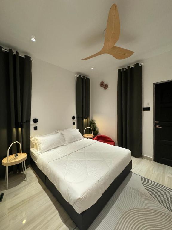 1 dormitorio con 1 cama y ventilador de techo en HOMESTAY SCANDINAVI at BUKIT MERTAJAM PENANG, en Kubang Semang