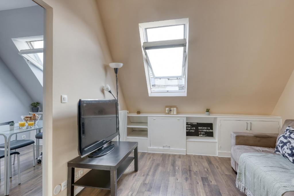 un salon avec un canapé et une télévision dans l'établissement Ideal & Comfy Cocoon at the Luxury Paris 16., à Paris