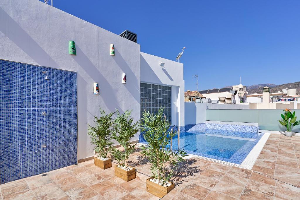 a villa with a swimming pool and some plants at Nerja Boutique 102 Deluxe in Nerja