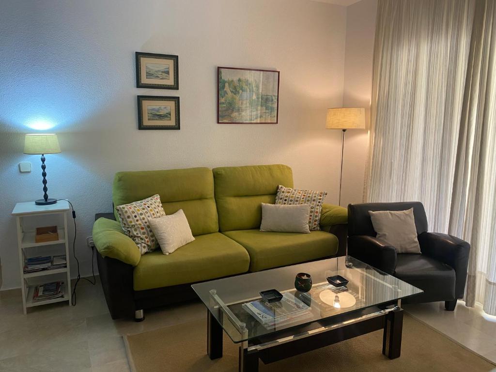 a living room with a green couch and a coffee table at Marina Bay Playa del Cristo in Estepona