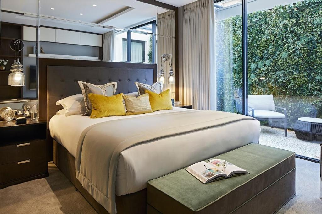 um quarto com uma cama grande e uma janela grande em Cheval Hyde Park Gate em Londres