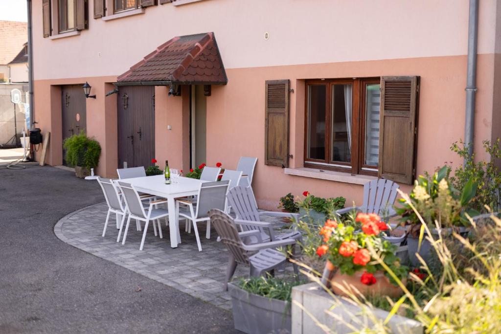 a table and chairs sitting outside of a building at SARL HARTWEG Les Amandiers in Beblenheim