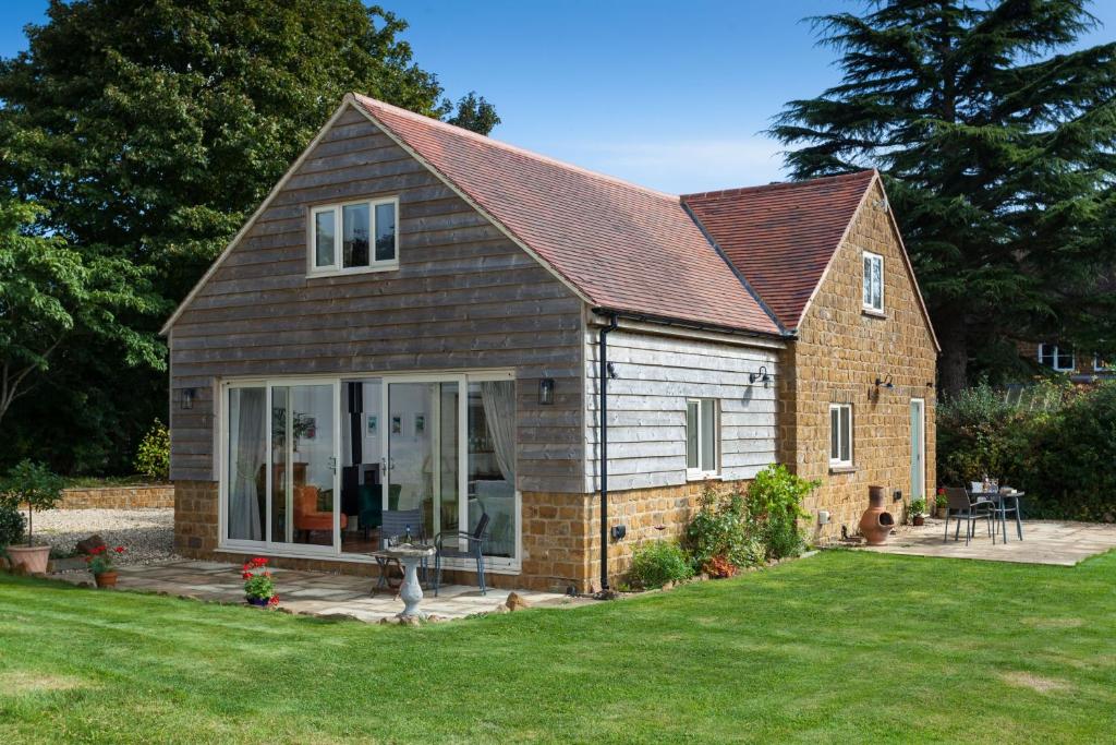 a house with a dog standing in the yard at The Sunset Retreat in Banbury