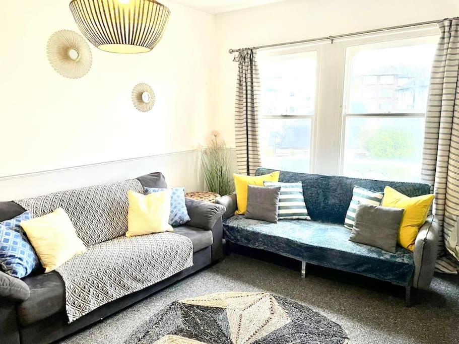 Central st Leonard’s Maisonette في سانت ليوناردز: غرفة معيشة مع أريكة ووسائد صفراء