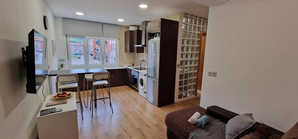 a kitchen and living room with a couch and a table at Mina La Camocha · 2 Hab · 4 pax · Wifi in Gijón