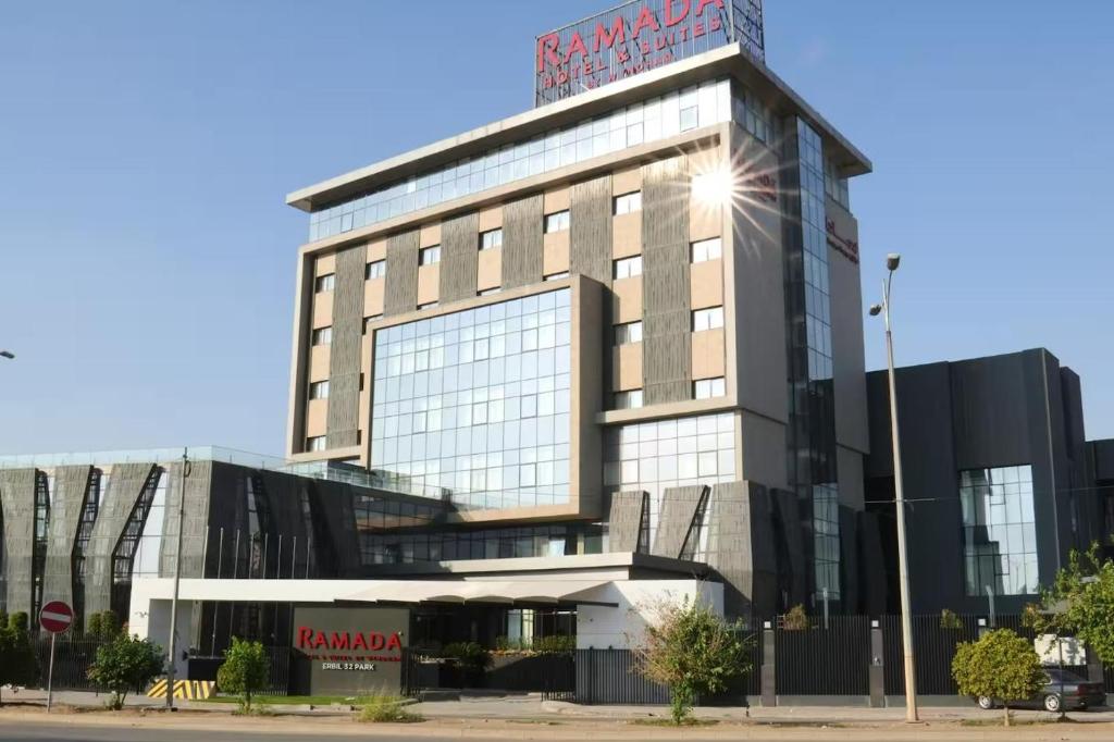 um edifício com um sinal em cima em Ramada Hotel & Suites by Wyndham Erbil 32 Park em Arbil