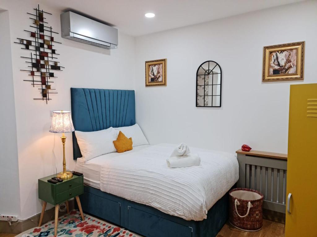 a bedroom with a bed with a blue headboard at SureBillionaire Homes II in London