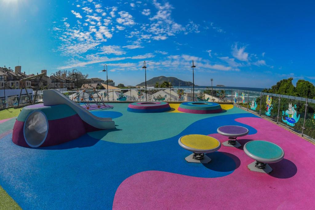 a playground with a slide and tables and chairs at Costao do Santinho Resort All Inclusive in Florianópolis