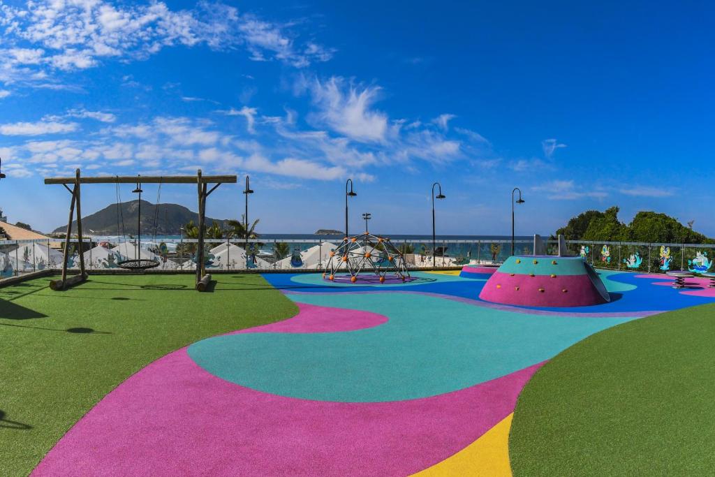 a park with a playground with a slide and swings at Costao do Santinho Resort All Inclusive in Florianópolis