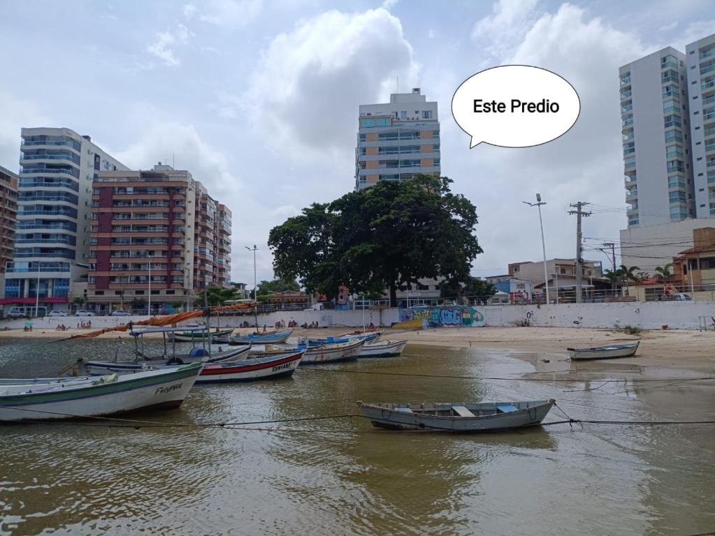 un grupo de barcos en el agua en una ciudad en Apartamento Pé na Areia, Wi-Fi e Garagem Privativa início da Praia do Morro, en Guarapari