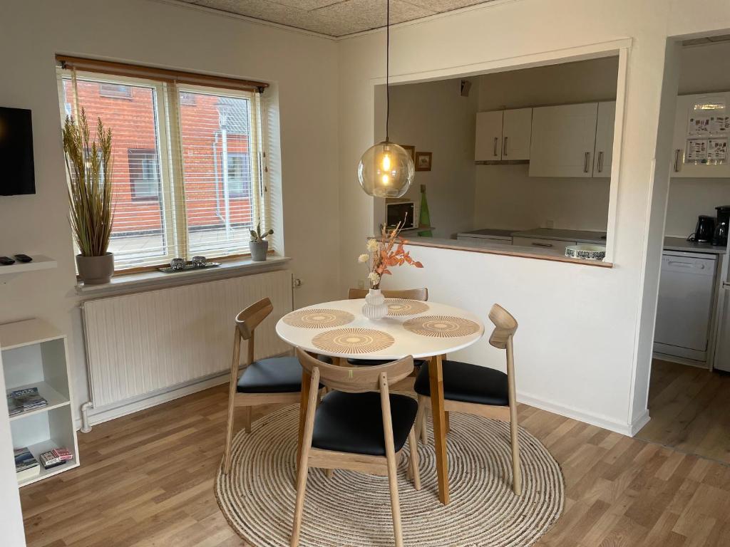 斯凱恩的住宿－Skjernaa-ferie/ Andersen Invest，厨房以及带桌椅的用餐室。
