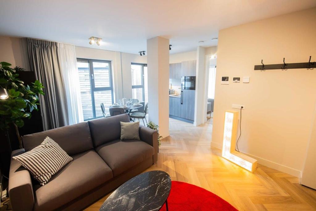 - un salon avec un canapé et une table dans l'établissement Alphabet Apartments 1BR serviced apartments, à Hilversum
