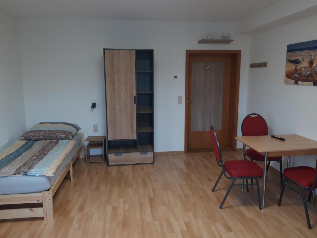 um quarto com uma cama, uma mesa e cadeiras em Vermietung Hänsel em Thiendorf