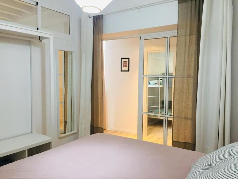 a bedroom with a bed and a large window at Disfruta, nuevo en Mentidero in Cádiz