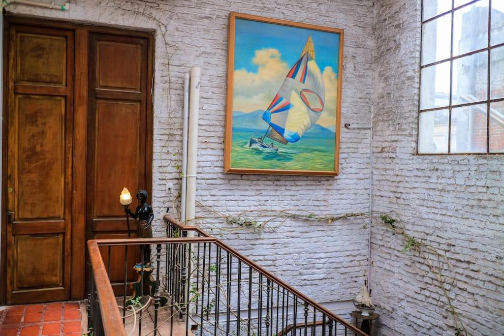 una pintura de un velero en una pared junto a una puerta en Galeón Nouveau (Apt 03). Terrace in The Oldtown, en Montevideo